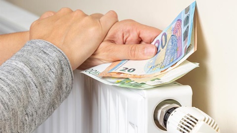 deux mains tenant des billets d'euros sur un radiateur